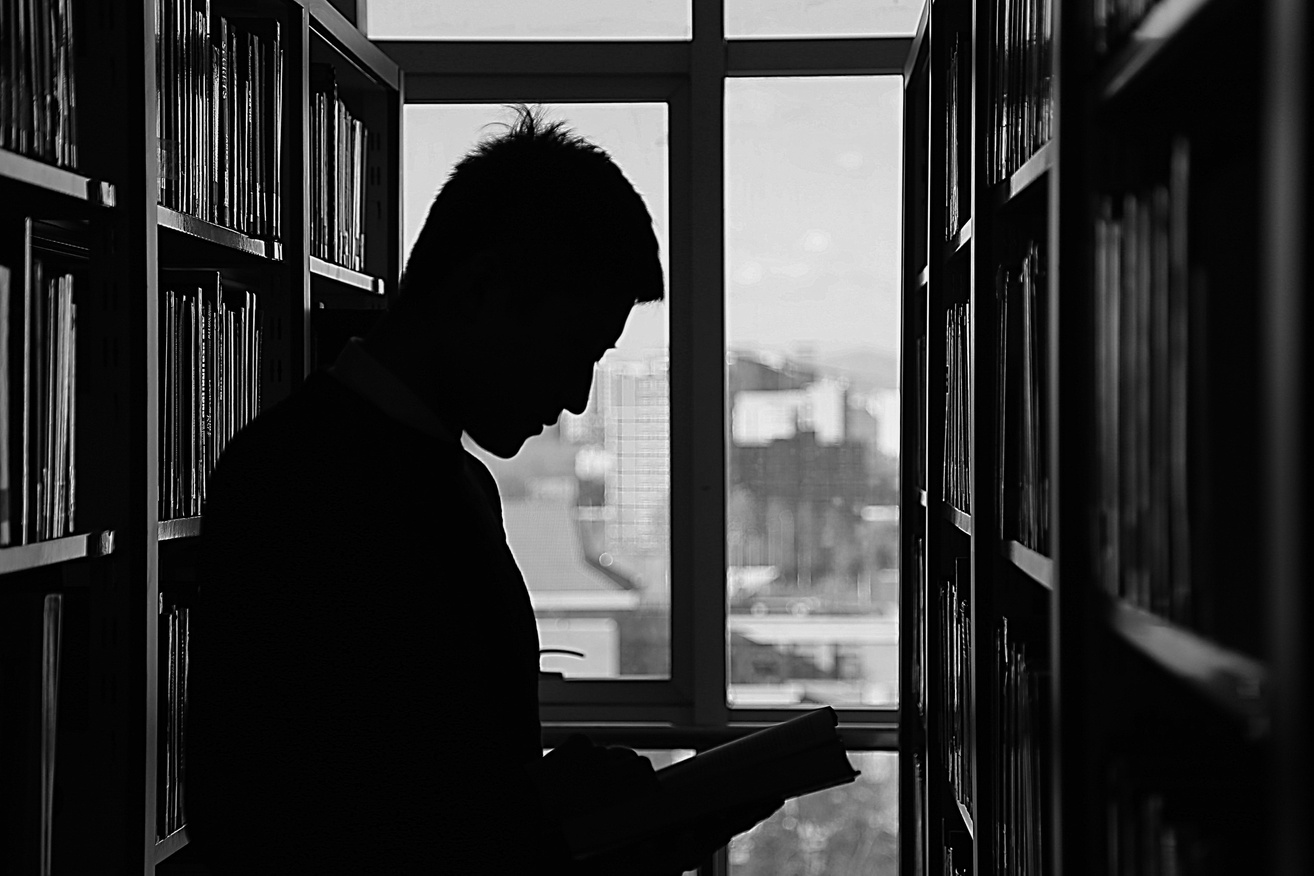 Man Reading Book at Library